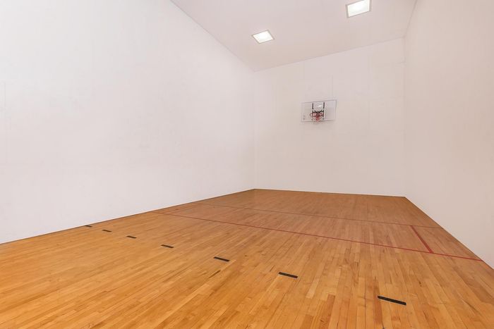 Bright indoor court featuring polished hardwood floors, perfect for basketball or other sports activities.