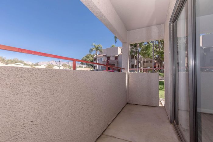 Charming balcony with serene views of lush greenery and distant mountains, perfect for relaxing in a tranquil setting.