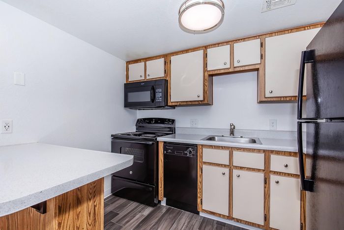 Modern kitchen with sleek black appliances, polished countertops, and stylish cabinetry offering a contemporary feel.