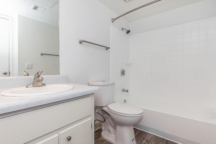 Bright and modern bathroom featuring a sleek white countertop, stylish fixtures, and a pristine bathtub for a spa-like experience.