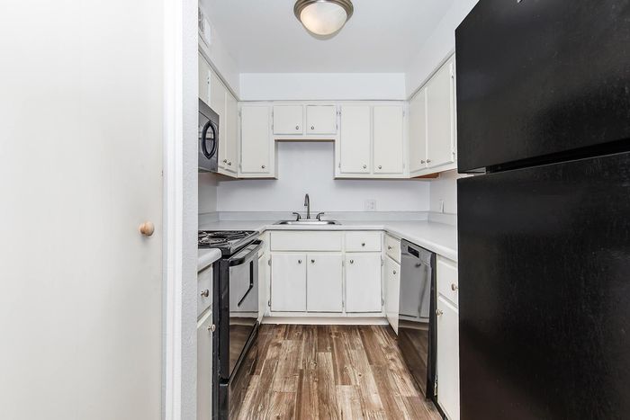 Charming U-shaped kitchen with modern appliances, sleek countertops, and elegant cabinetry.