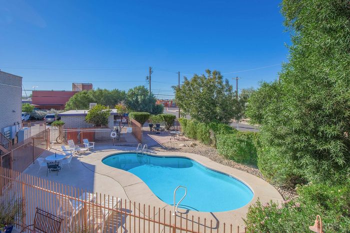 Inviting outdoor pool surrounded by lush greenery and seating area, perfect for relaxation and leisure.
