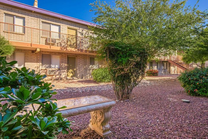 Charming apartment building surrounded by lush greenery and a peaceful garden setting, perfect for relaxation.