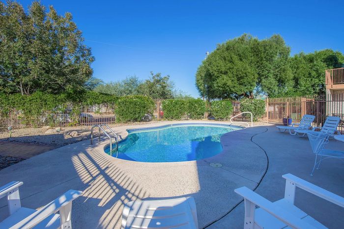 Inviting outdoor pool area surrounded by lush greenery and cozy seating, perfect for relaxation and leisure.