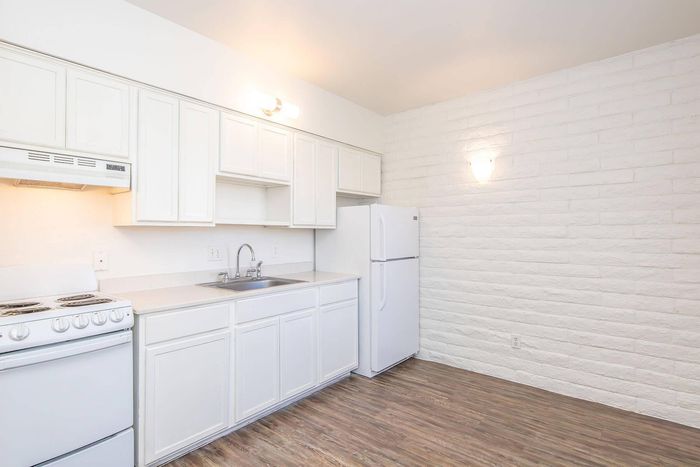 Bright and modern kitchen with sleek white cabinetry, spacious countertops, and a cozy ambiance. Perfect for culinary adventures.