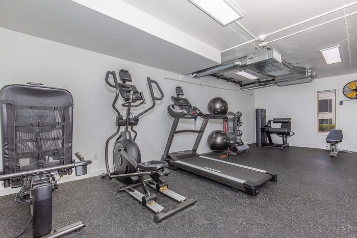 Modern fitness room with state-of-the-art equipment, including treadmill, elliptical, and strength machines, perfect for an active lifestyle.
