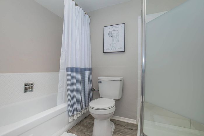 Contemporary bathroom featuring elegant tilework, a sleek toilet, and a chic shower curtain with blue accents.