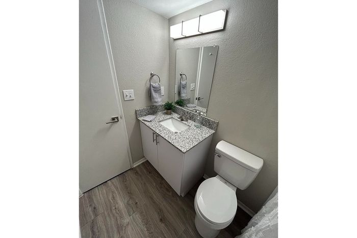 Modern bathroom with elegant granite countertop, sleek fixtures, and cozy lighting, perfect for a refreshing start.