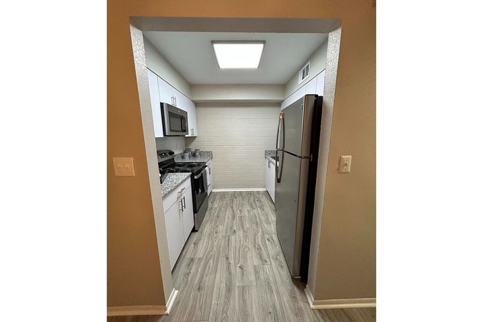 Modern kitchen with sleek appliances, elegant countertops, and stylish flooring, offering a contemporary cooking space.