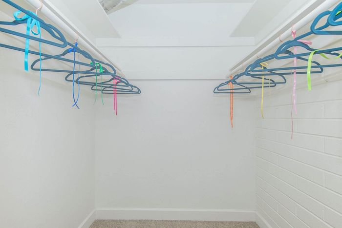 Spacious walk-in closet featuring an array of colorful hangers, perfect for organizing your wardrobe.