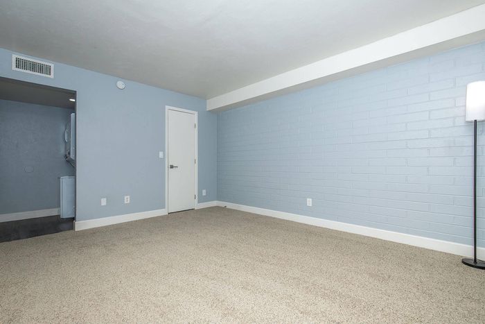 Bright, spacious room with light blue accents and cozy carpeting, perfect for a modern living space.