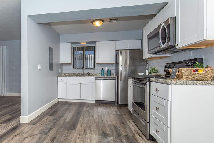Modern kitchen with sleek stainless steel appliances, elegant granite countertops, and stylish white cabinetry, offering a chic and functional cooking space.