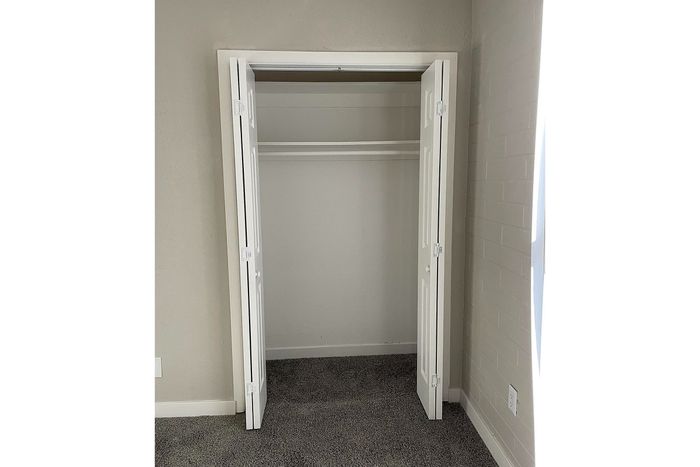 Bright and spacious closet with double folding doors, perfect for maximizing storage in your elegant home.