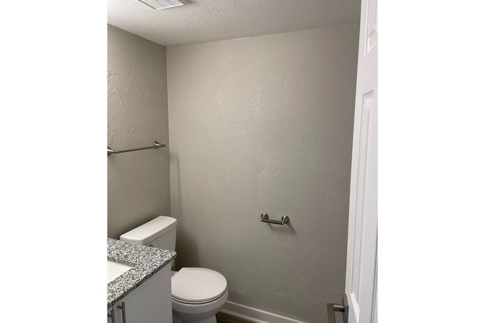 Modern minimalist bathroom with elegant granite counter, sleek fixtures, and neutral tones for a serene ambiance.