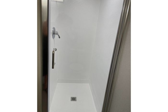Modern glass shower with sleek chrome fixtures in a pristine bathroom.