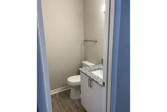 Sleek bathroom with elegant granite countertop, modern fixtures, and wood flooring for a contemporary look.
