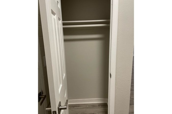 Elegant closet space with sleek white door and modern handles, perfect for organized living.