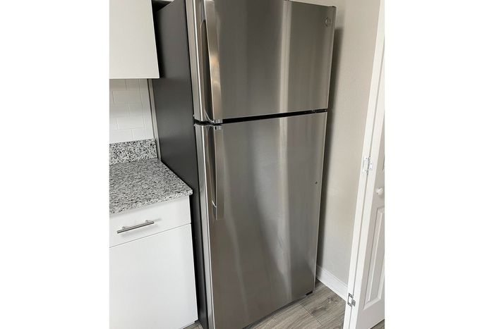 Modern kitchen showcasing a sleek stainless steel refrigerator next to elegant granite countertops.