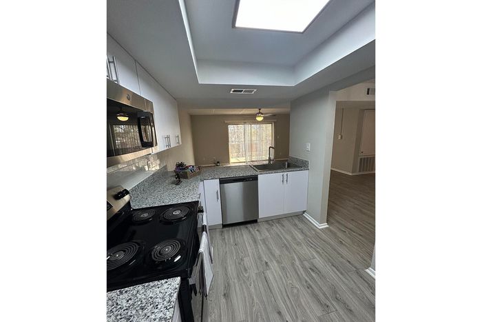 Modern kitchen with sleek granite countertops, stainless steel appliances, and ample natural light.