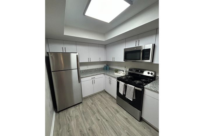 Modern kitchen with sleek stainless steel appliances, granite countertops, and stylish cabinetry.