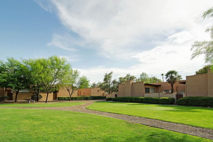 Scenic courtyard view with lush green lawns and well-maintained pathways in a serene residential complex setting.