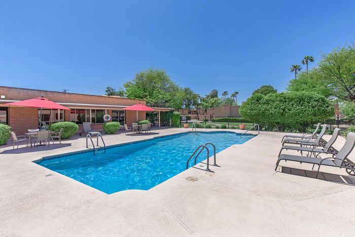 Inviting outdoor pool area with sun loungers and shaded seating, perfect for relaxation and social gatherings.