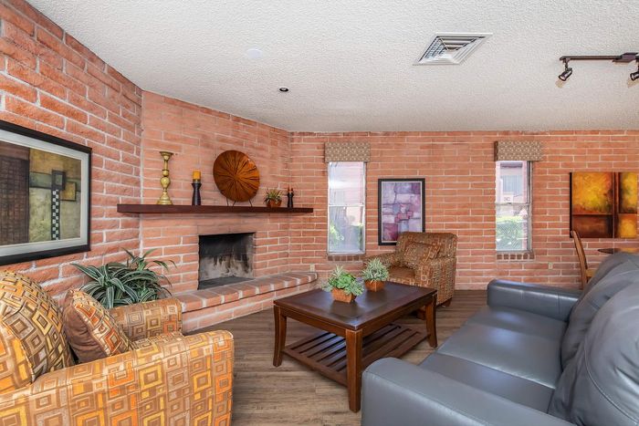 Charming living room with rustic brick walls, cozy fireplace, and elegant modern decor.