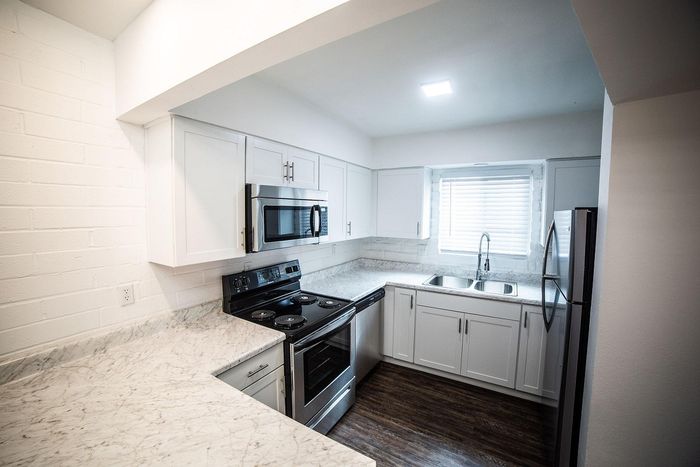 Modern kitchen with sleek stainless steel appliances, elegant white cabinetry, and luxurious marble countertops.
