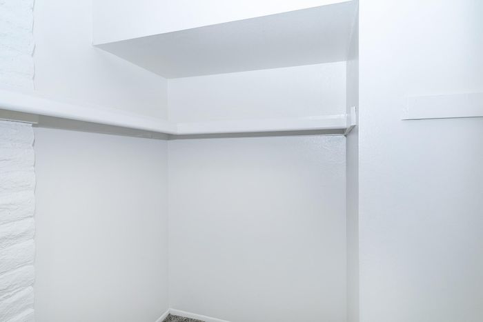 Spacious white walk-in closet with ample shelving and modern design.