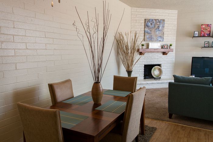 Inviting apartment living area with a cozy dining setup, elegant modern decor, and a stylish brick fireplace.