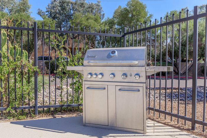 Sleek outdoor stainless steel barbecue grill set in a picturesque garden area, perfect for entertaining and alfresco dining.