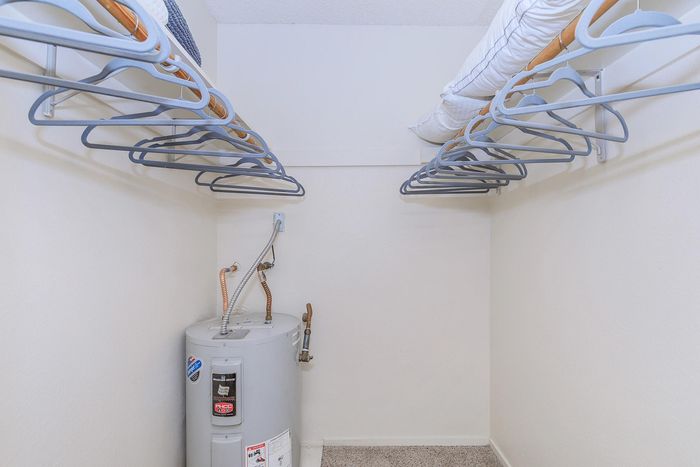 Spacious apartment closet with ample storage space and water heater, perfect for organized living.