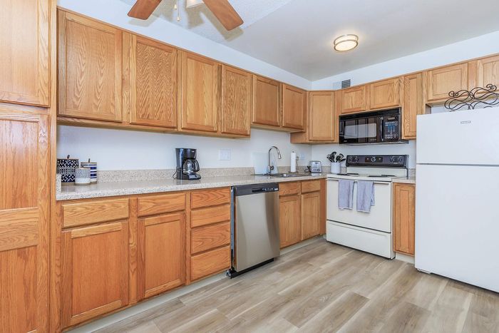 Charming kitchen with warm wooden cabinets, modern appliances, and elegant countertops, perfect for culinary enthusiasts.