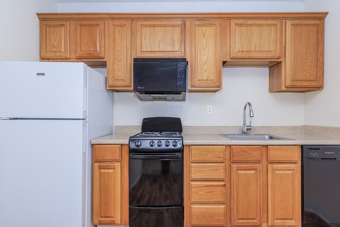Bright and modern kitchen with sleek white appliances, granite countertops, and elegant wooden cabinetry.