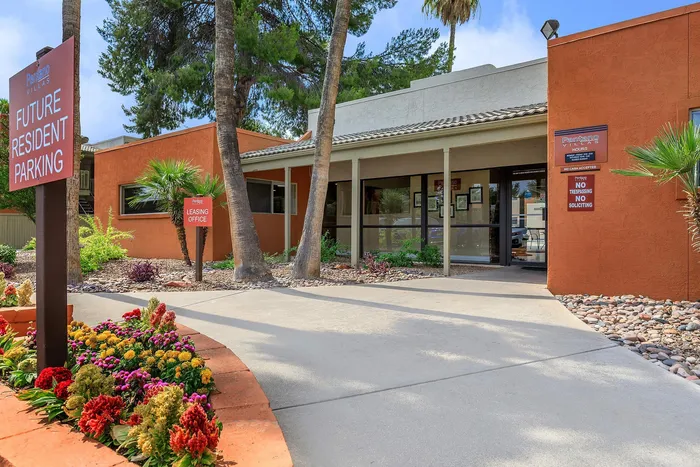 Charming leasing office exterior with beautiful landscape and future resident parking at Pantano Villas.