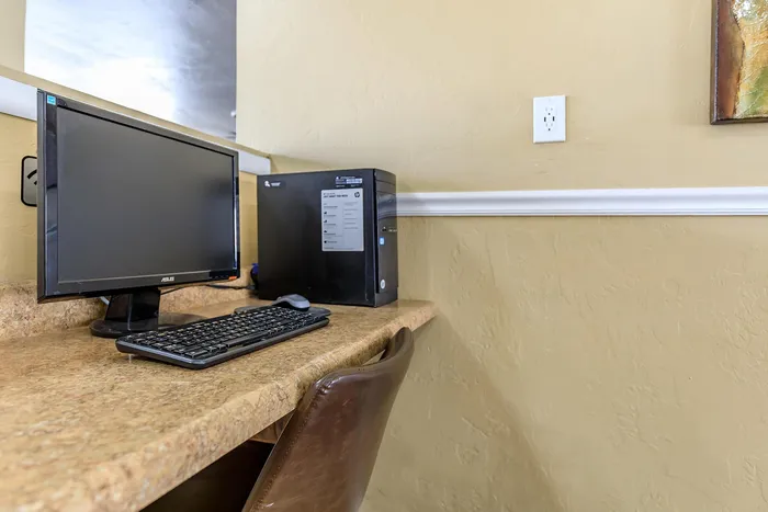 Inviting home office nook featuring a sleek computer setup on a polished wooden desk, perfect for productivity and remote work.