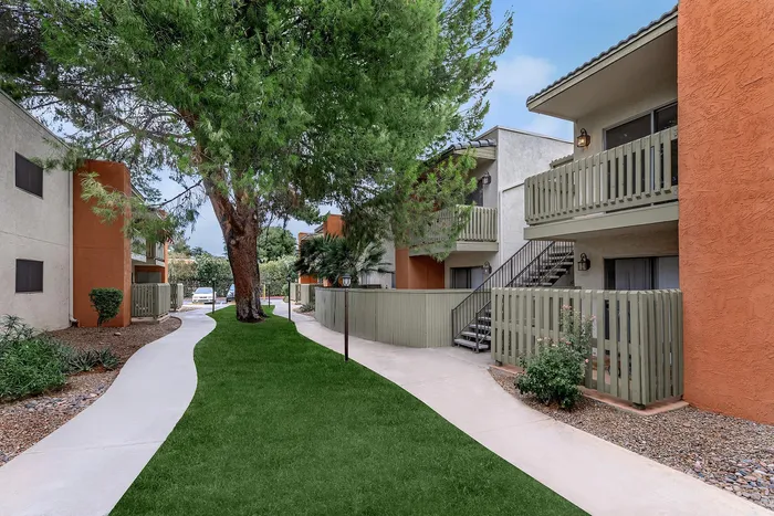 Charming apartment complex with lush greenery, inviting pathways, and modern balconies, offering a serene living environment.