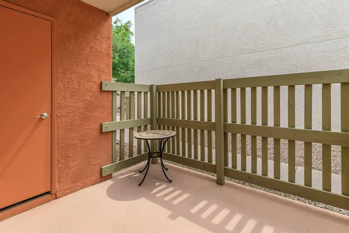 Charming outdoor patio with warm earth tones, featuring a cozy table perfect for relaxation.