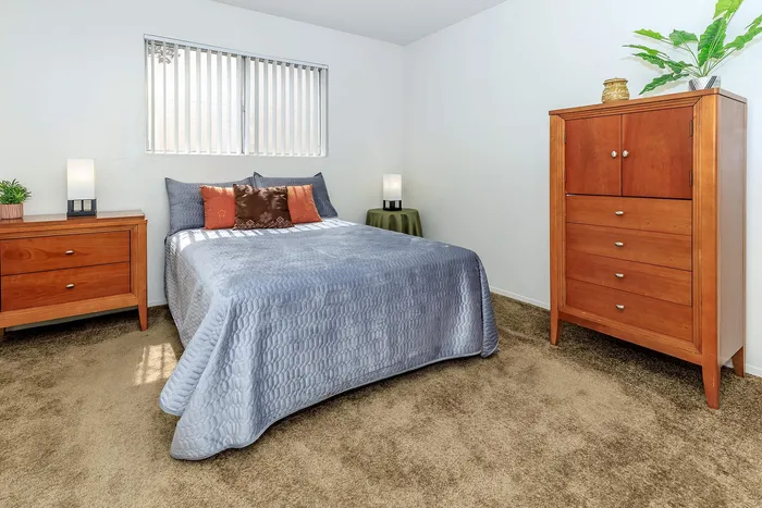 Inviting bedroom with plush bedding, elegant wooden furniture, and soft lighting creating a cozy ambiance.
