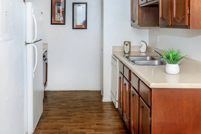 Charming kitchen with rich wooden cabinetry, modern appliances, and elegant decor on sleek countertops.