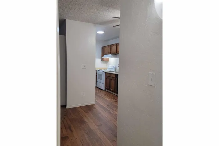 Inviting kitchen view with rustic wooden cabinets, modern appliances, and elegant hardwood flooring.