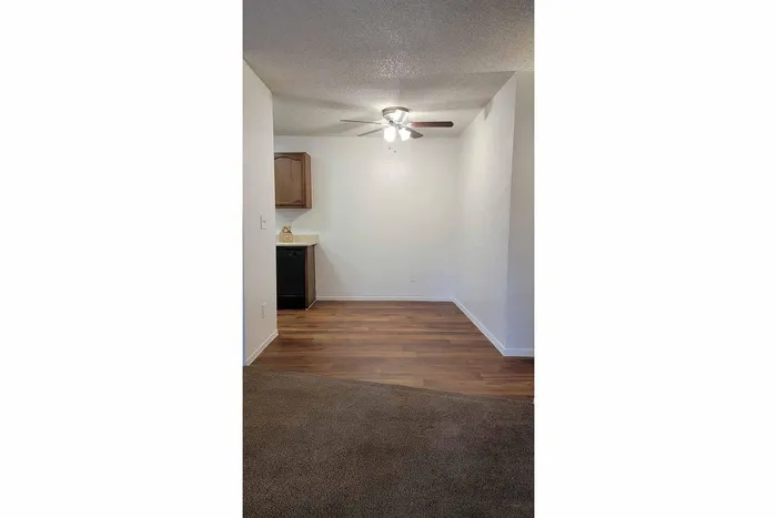 Charming dining area with modern ceiling fan, elegant wood flooring, and stylish cabinetry.