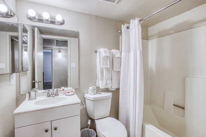 Modern bathroom featuring sleek vanity, large mirror, and elegant lighting, ideal for a stylish living experience.