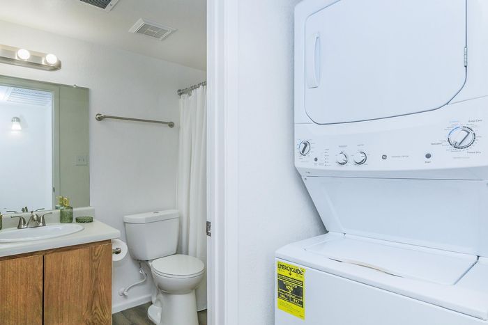 Modern bathroom with in-unit stacked washer and dryer, offering convenience and efficient use of space.