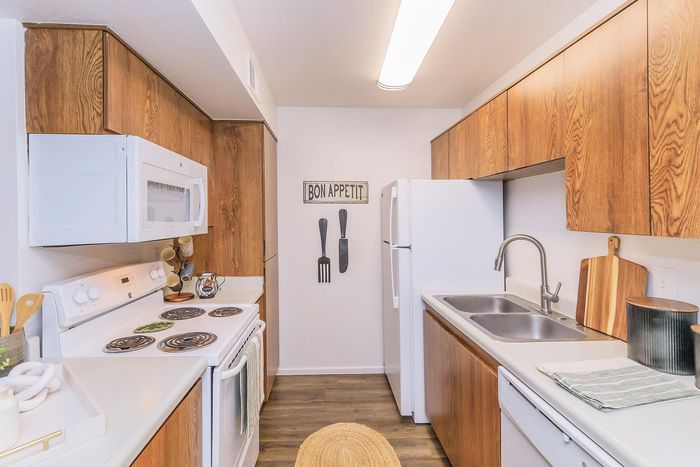 Cozy galley kitchen with warm wood cabinetry, modern appliances, and inviting decor for a charming culinary experience.