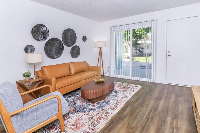 Contemporary living room with a stylish leather sofa, elegant decor, and ample natural light from large sliding doors.