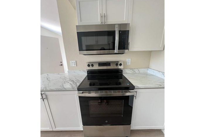 Modern kitchen featuring sleek black appliances and elegant marble countertops, perfect for contemporary living.