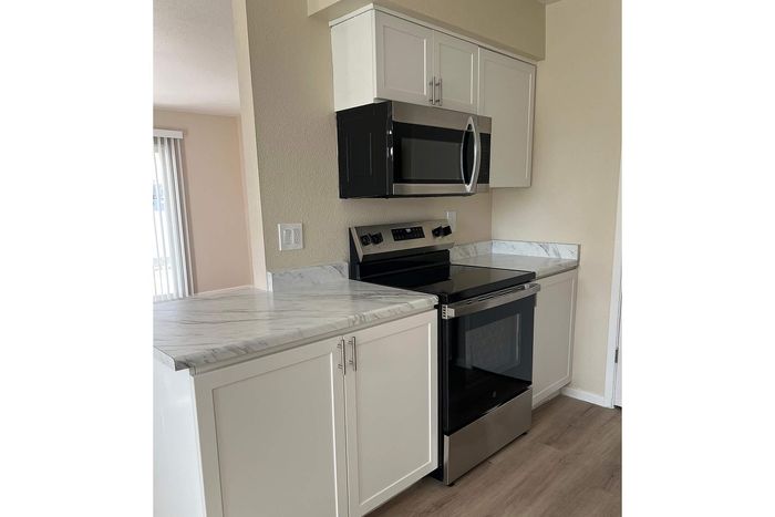 Modern kitchen with sleek stainless steel appliances, elegant marble countertops, and bright natural lighting.