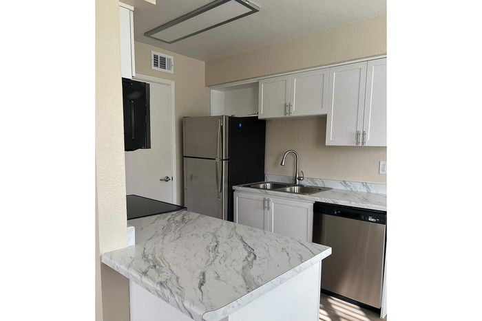 Contemporary kitchen with elegant marble countertops, sleek stainless steel appliances, and modern cabinetry.