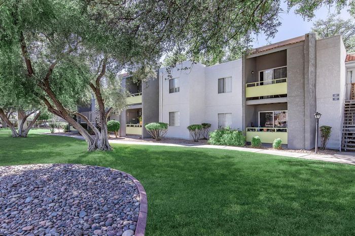 Charming modern apartment complex nestled in lush greenery with a serene garden view.